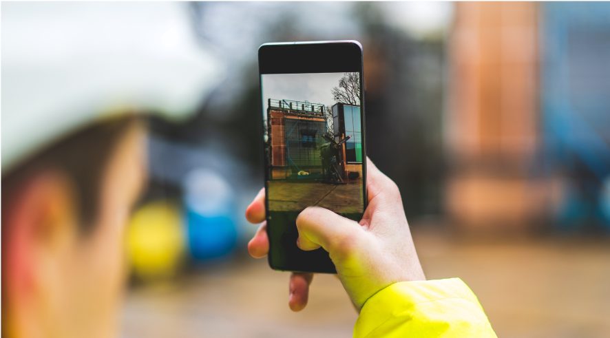 first-person perspective of someone taking a photograph of a job site on a smart phone