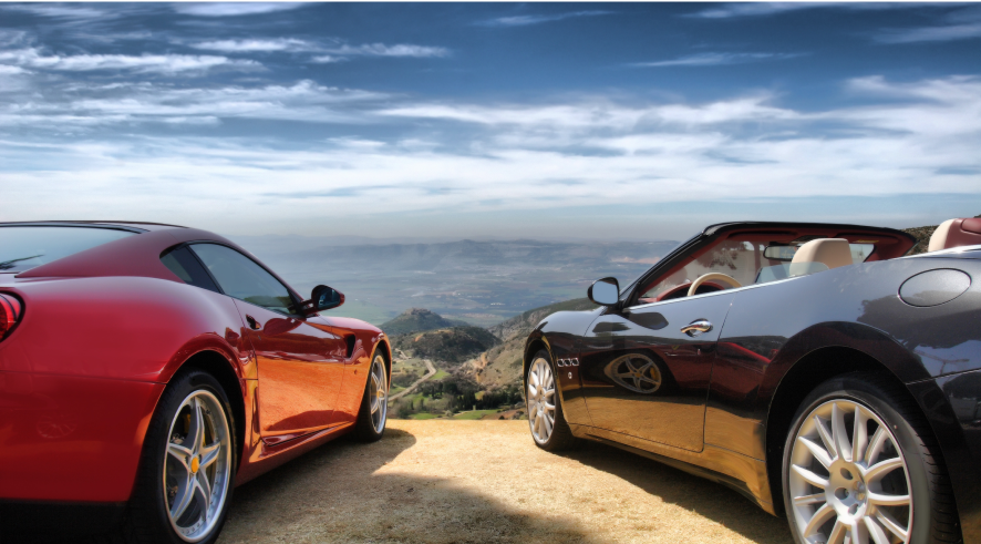 two sports cars parked with a view